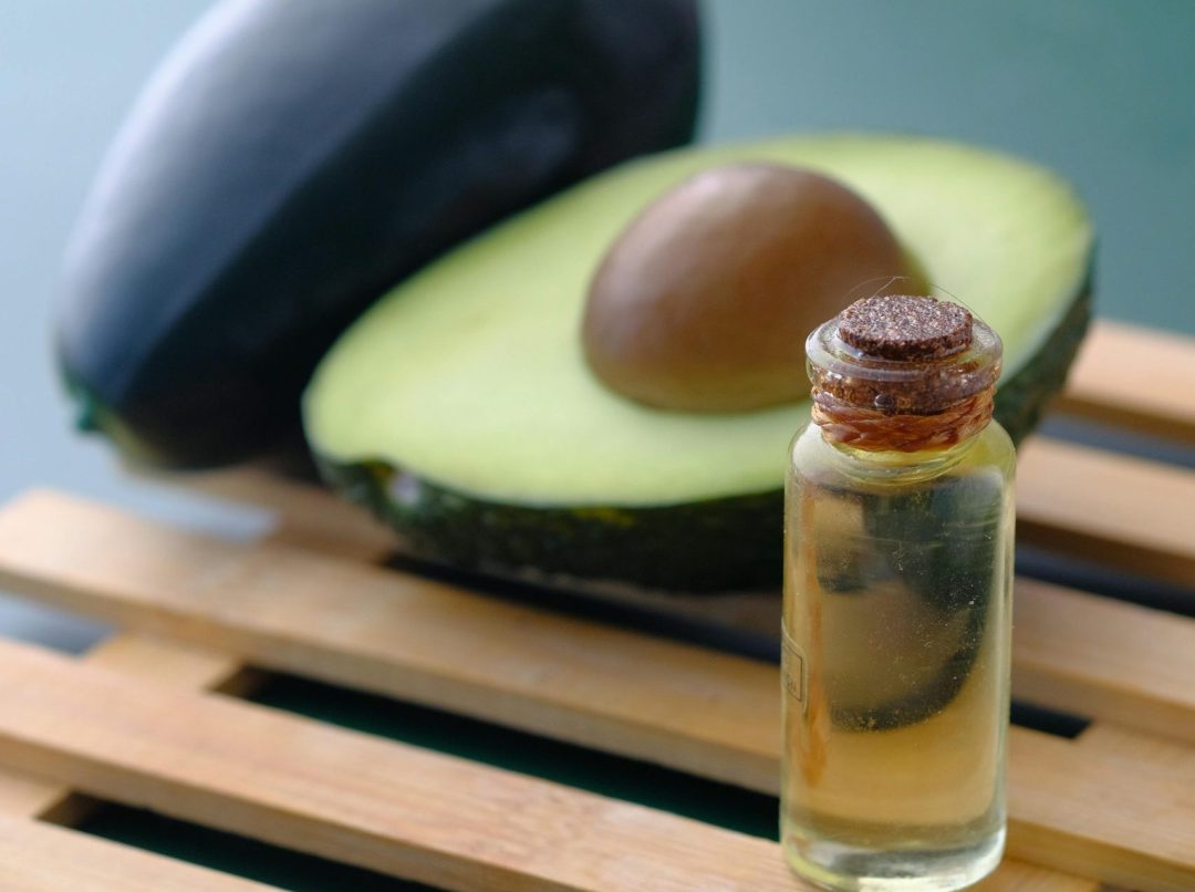 Ulje od avokada: presečeni avokado i flašica ulja